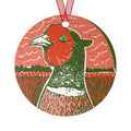 A round hanging ornament featuring a stylized pheasant bird illustration in red, green, and white, suspended by a red ribbon on a plain white background.