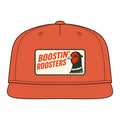 An orange snapback cap with a rectangular front patch that reads 'BOOSTIN' ROOSTERS' in orange text on a cream background, alongside a stylized rooster illustration. The cap is shown on a plain white background.